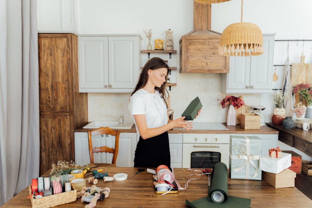 pexels-photo-5486778 A woman wrapping presents in a cozy kitchen with ribbon and paper around.